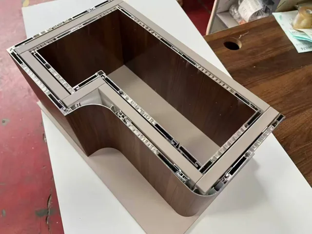 Cutaway furniture assembly with cellular panels and coordinated aluminium perimeter profiles